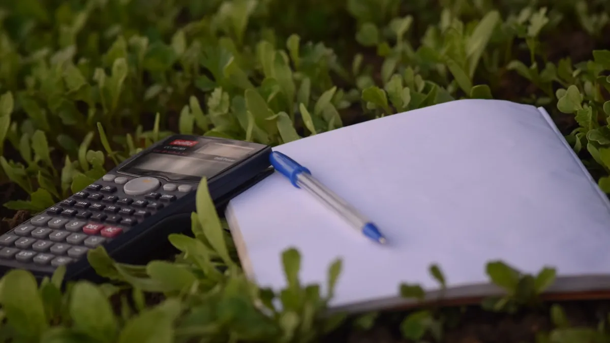 Caneta azul sobre papel ao lado de calculadora, representando auditoria de faturas de plano de saúde