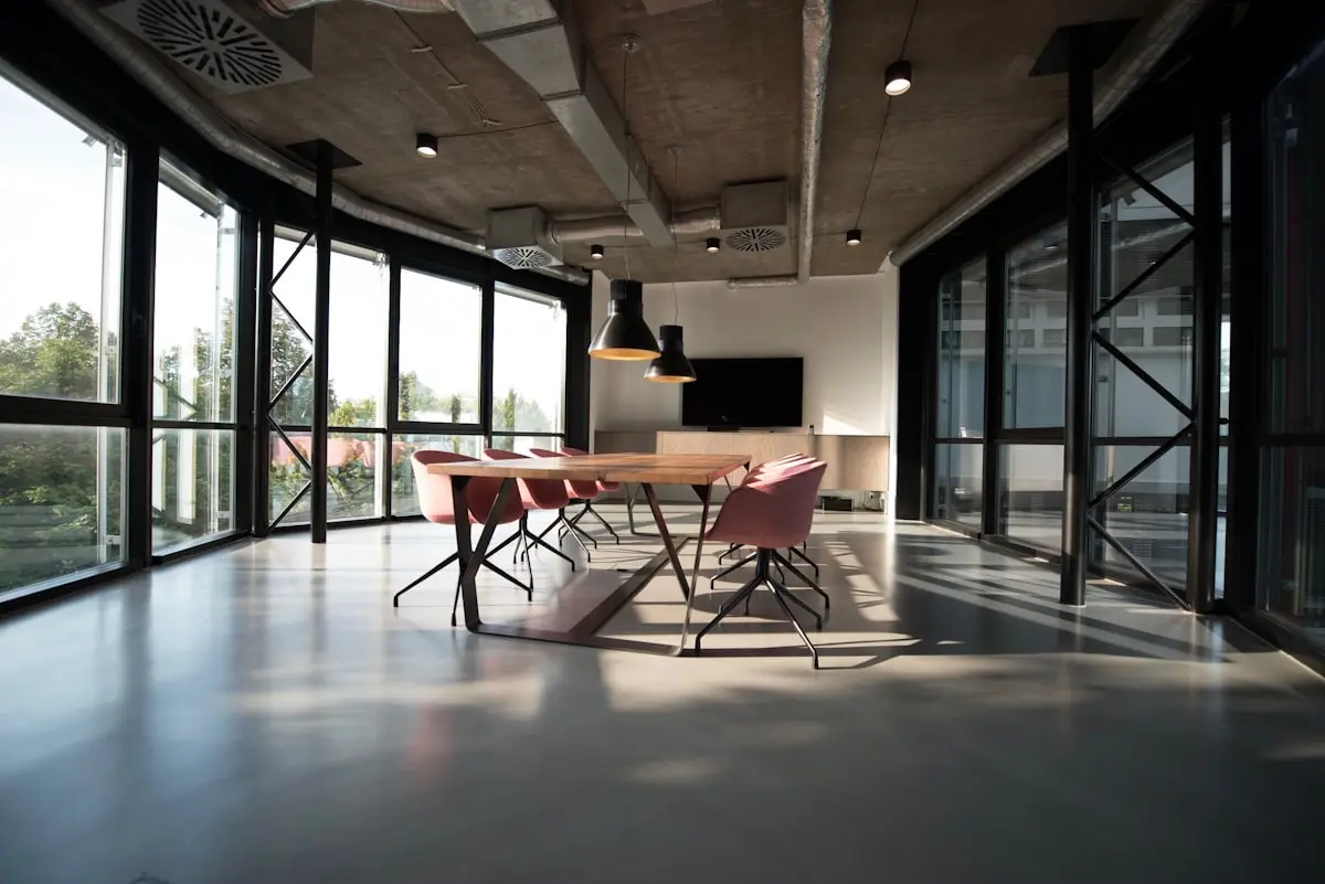 Escritório com iluminação natural e plantas promovendo ambiente saudável conforme NR-1