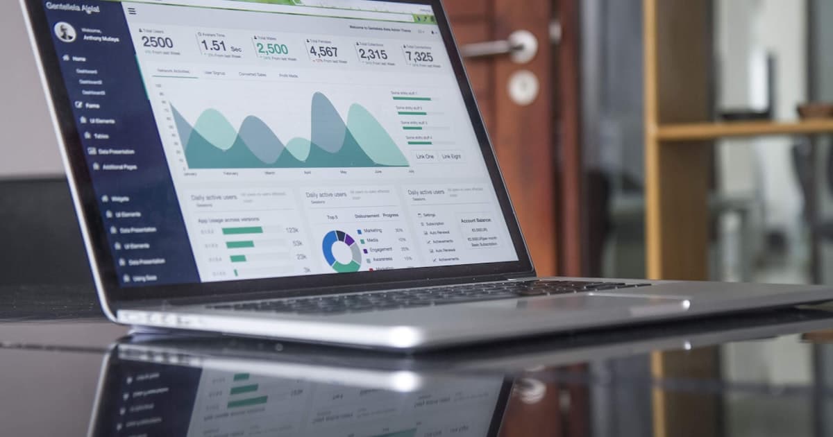 Profissional de RH acessando portal de gestão de benefícios em laptop com dashboards de saúde corporativa visíveis na tela