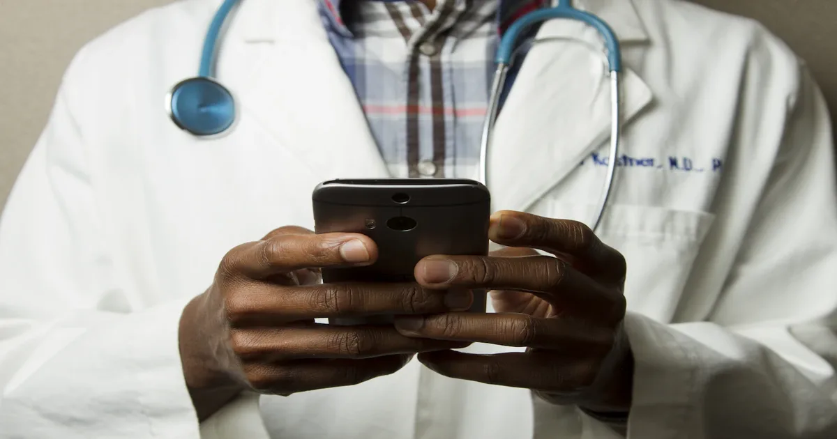 Grupo diverso de colaboradores em sala de bem-estar corporativa, alguns fazendo alongamento e outros verificando métricas de saúde em tablet