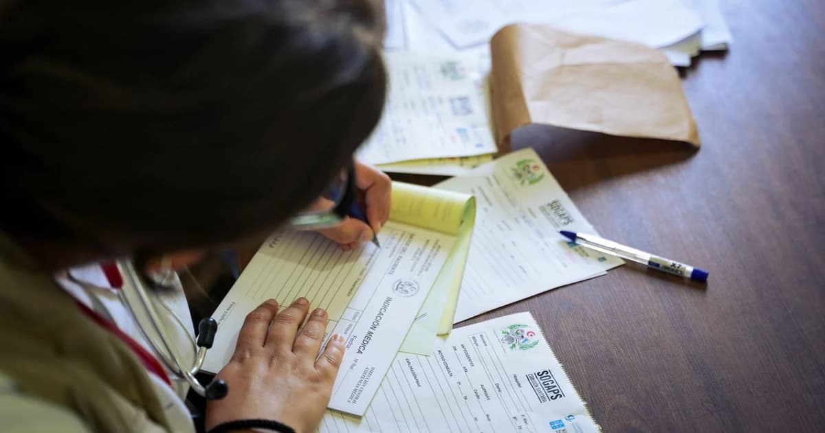 Profissional de saúde preenchendo formulário de declaração de saúde sobre a mesa